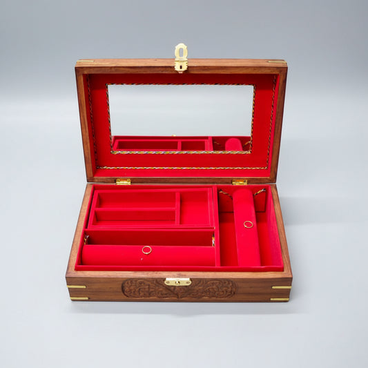 Open jewelry box with red interior and wooden exterior on a dark surface