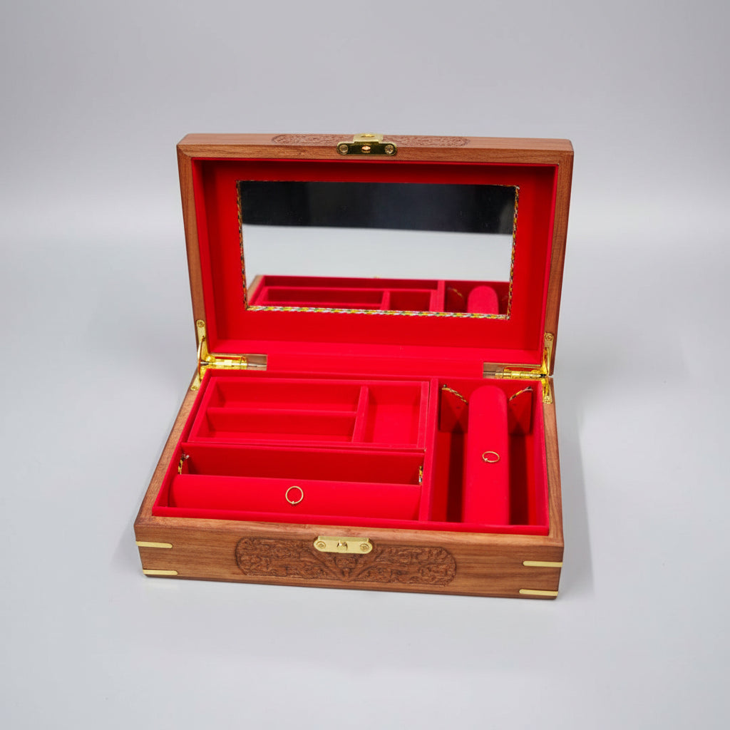 Open red jewelry box with gold interior on a dark surface